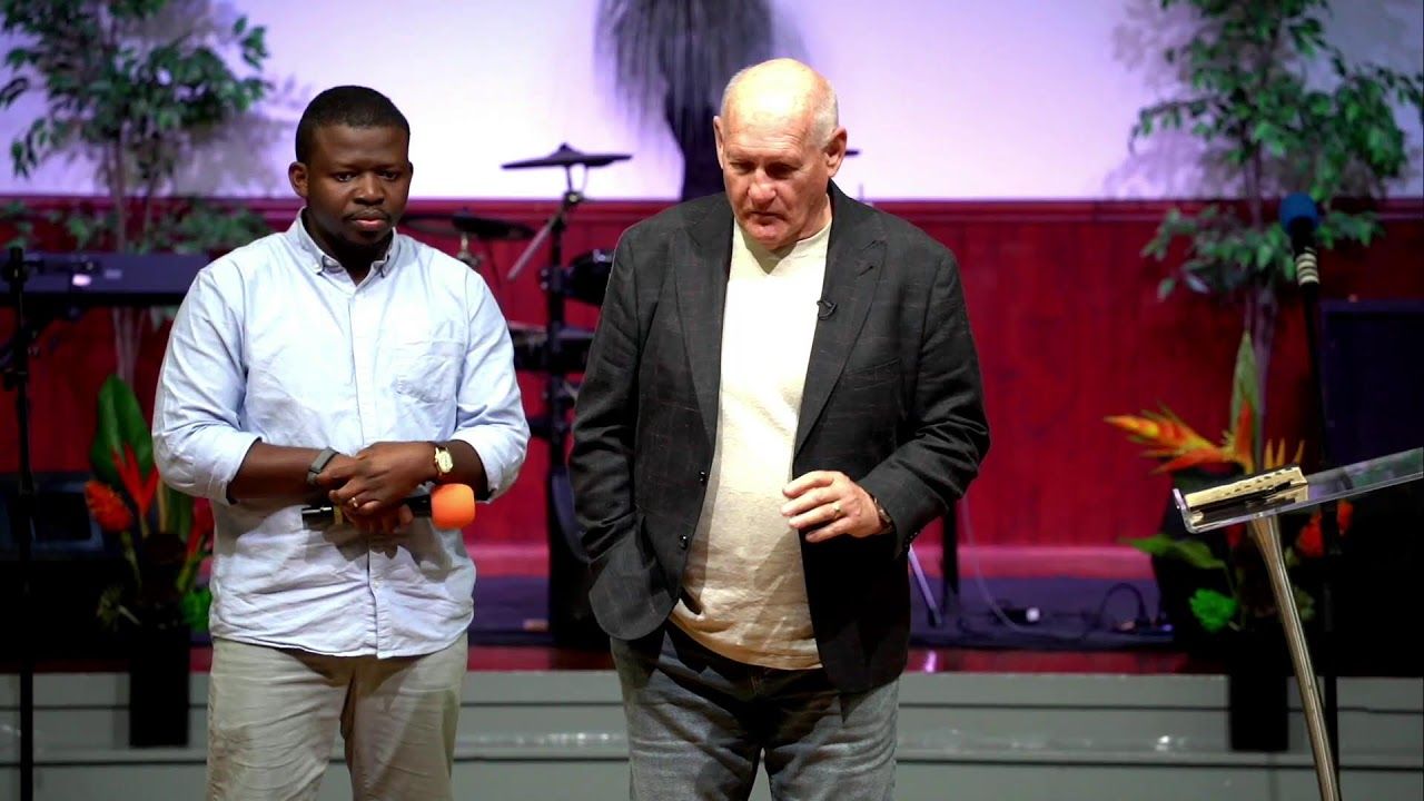 Two men standing together on stage during the Sunday evening service at CoastWIDE Church