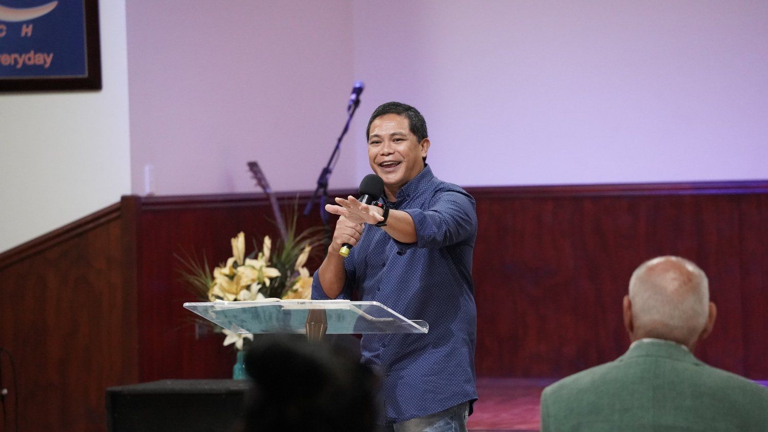 Pastor Herane Suralta smiling as he preaches at CoastWIDE Church in Arundel, Gold Coast