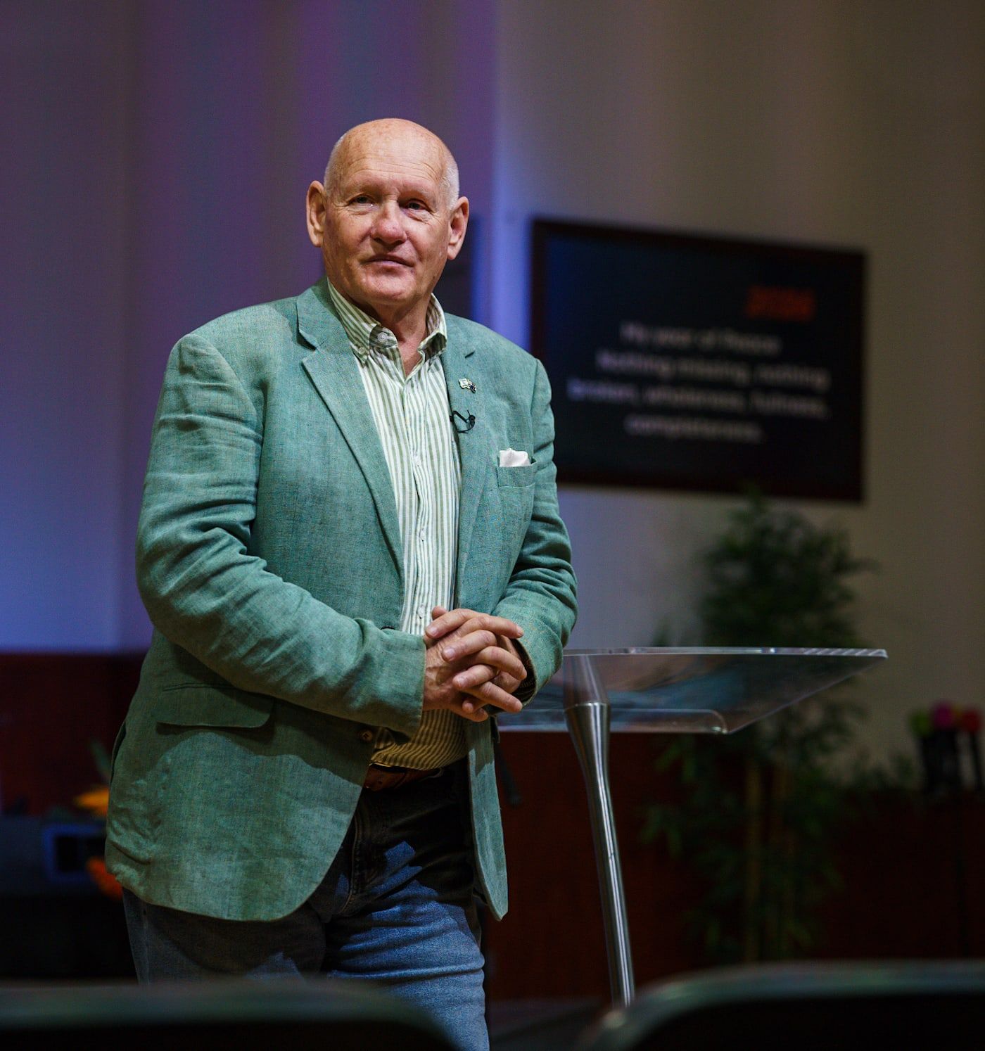 Senior Pastor Shayne Cunningham of CoastWIDE Church smiling in a green jacket, hands clasped