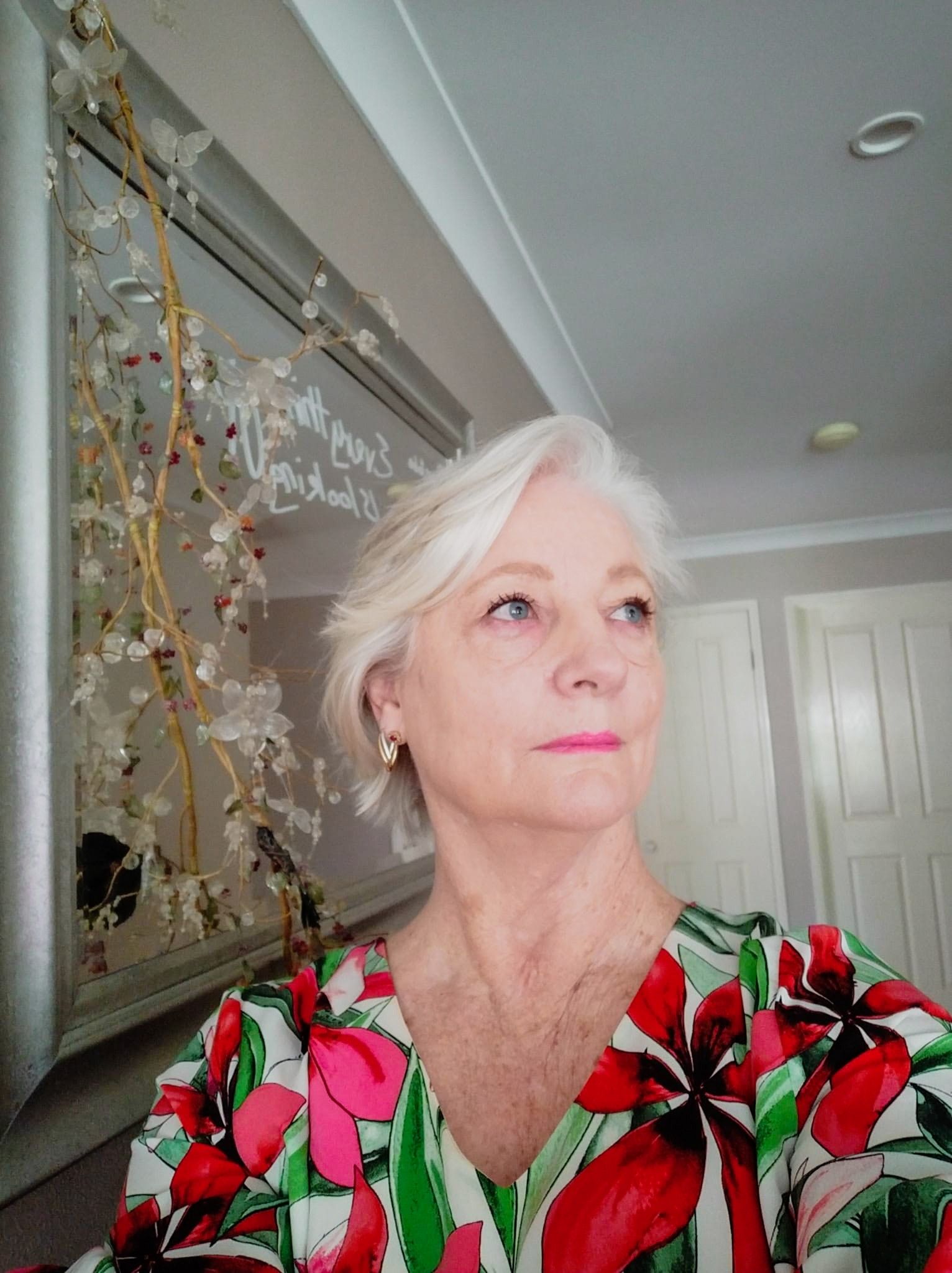 Pastor Susan Cunningham of CoastWIDE Church in a red and green floral top, looking to the side